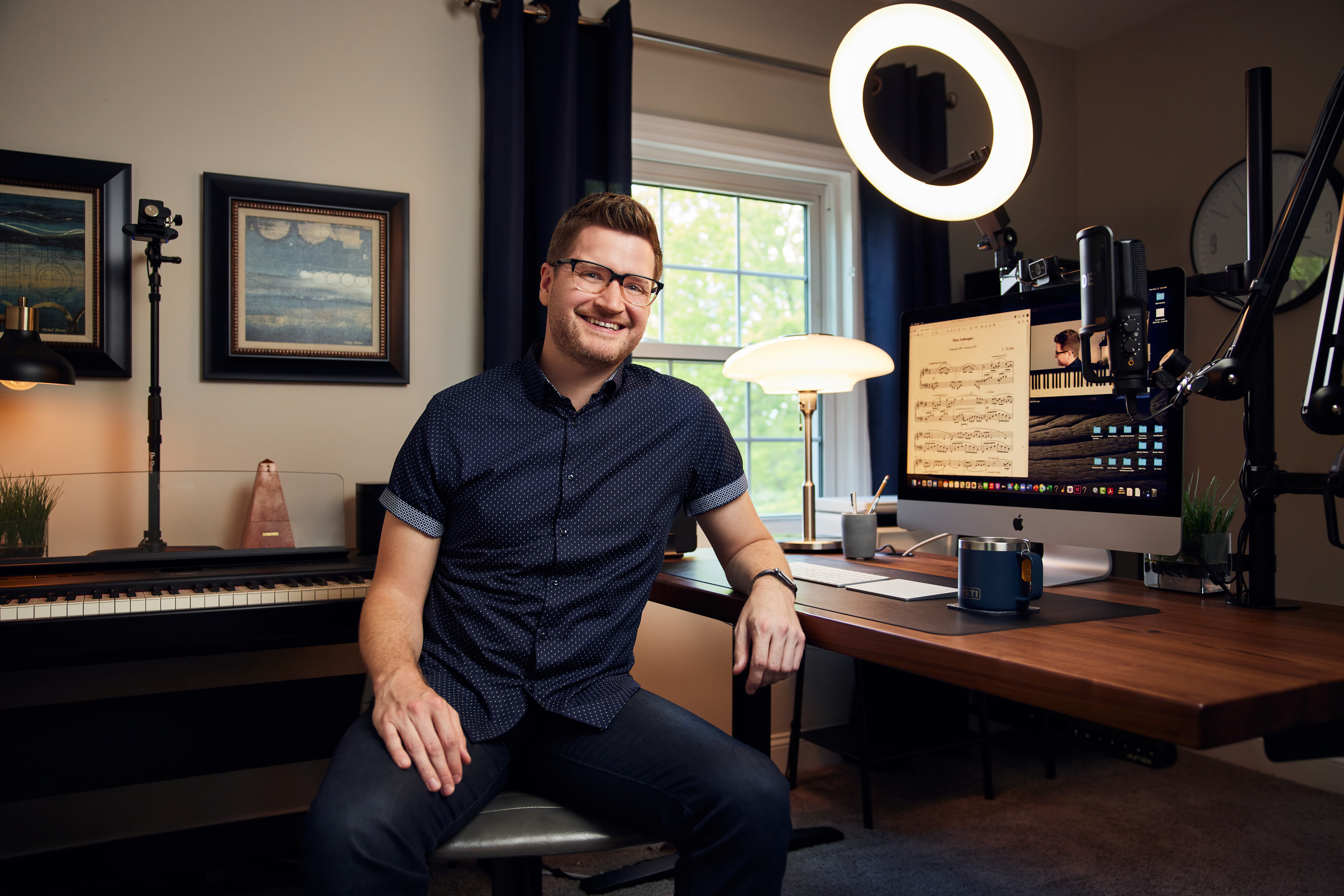 Davis Dorrough sitting in his virtual studio space with ring light, computer, and digital piano