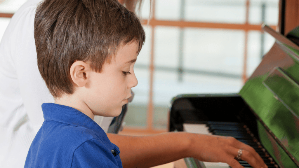 young boy learning to play the piano